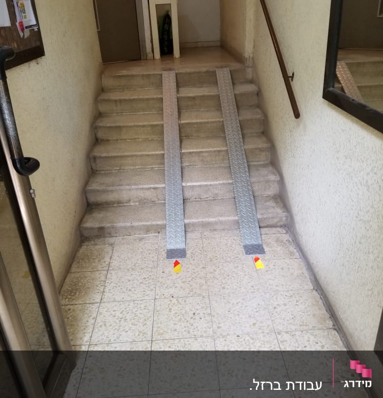 שני מסלולים מתכתיים על מדרגות עם מעקה בצד